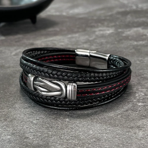 Detail of multi-layer braided leather bracelet with infinity knot and red stitching