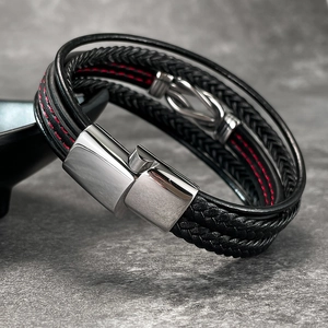 Detail of multi-layer braided leather bracelet with red stitching and magnetic buckle