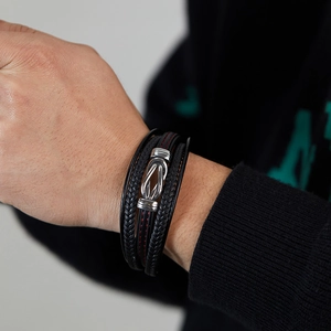 Close-up of men's multi-layer braided leather bracelet with silver buckle and red stitching