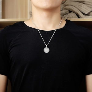 Collier avec pendentif rond en acier inoxydable argenté poli porté par un homme