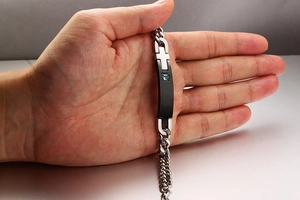 Detail of cross bracelet for men with blue zircon on heavy Cuban link chain
