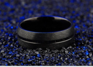 Primer plano de anillo para hombre de titanio negro con textura cepillada y ranura azul