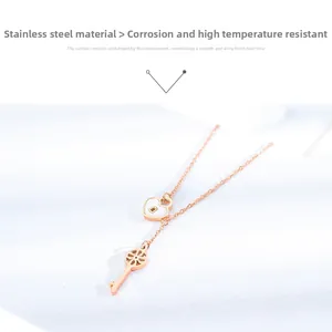 Detail of rose gold heart lock and key pendants on a stainless steel necklace