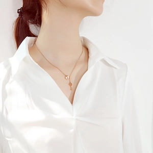 Minimalist rose gold titanium necklace with heart lock and key pendants on female model