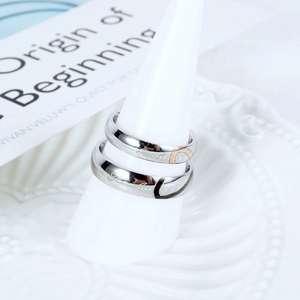 Close-up of matching couple rings with half-heart designs and script engraving