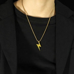 Detalle de un collar con colgante de rayo dorado y cadena de bolas pulida en un modelo