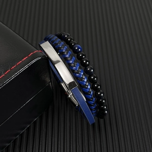 Détail d'un ensemble de bracelets en cuir multicouche avec perles et plaque argentée