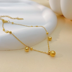 Nahaufnahme der minimalistischen Goldkugel-Fußkette mit verstellbarem Karabinerverschluss