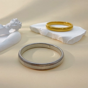 Macro detail of gold and silver plated titanium steel bangles with snake bone texture