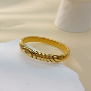 Detail view of a gold spiral texture titanium steel bracelet with polished finish