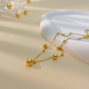 Minimalistisches geometrisches Fußkettchen aus Titanstahl mit goldenen Perlen für Damen