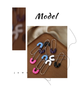 Macro shot of colorful enamel safety pin earrings made of polished stainless steel