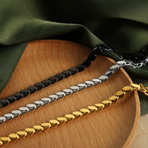 Hip-hop punk oval link necklace in gold, silver and black finishes on green satin