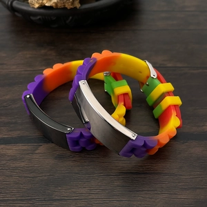 Detail of adjustable silicone ID bracelets with brushed metal plates on wood surface