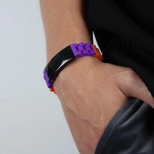 Detail of a sporty silicone bracelet with purple and orange links on wrist