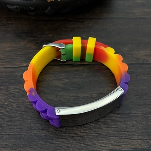 Detail of rainbow silicone bracelet with adjustable strap and silver metal id plate