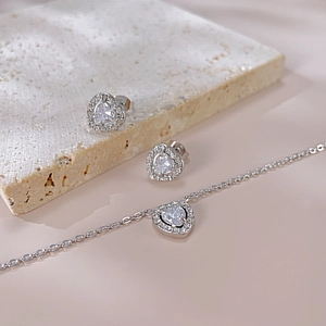 Détail d'un ensemble de bijoux cœur en argent avec cristaux brillants sur une pierre