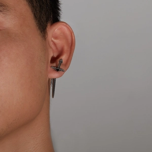 Detailansicht eines silbernen Kelten-Schwert-Ohrrings, der den Piercing-Stil am Ohr zeigt