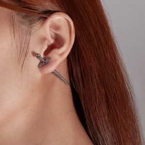 Detail eines Vintage-Silberschwert-Ohrrings mit keltischem Knoten am Ohrmodell