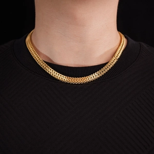 Close-up of a gold-plated Cuban chain necklace featuring dense woven craftsmanship on model