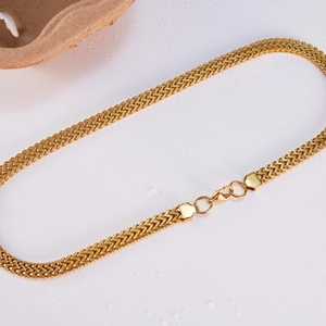 Close-up of golden wheat chain in stainless steel with lobster clasp and wood detail