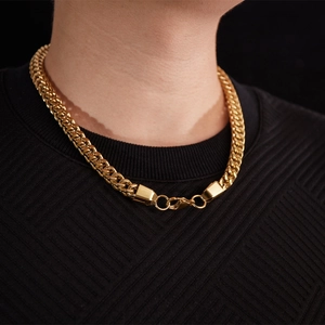 Close-up of thick golden stainless steel Cuban link chain with secure lobster clasp on neck