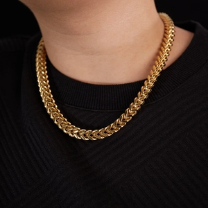 Close-up of thick gold Cuban curb chain necklace on model neck with streetwear style