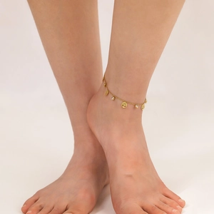 Gold stainless steel anklet with Tree of Life charms and zircon inlay on a model's ankle