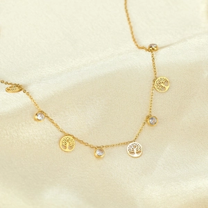 Golden Tree of Life necklace with cubic zirconia pendants on luxury champagne silk