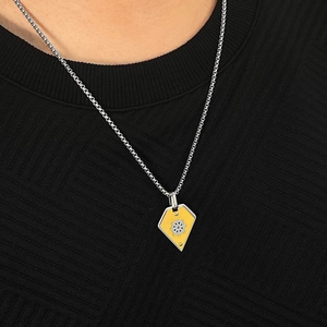 Close-up of a shield-shaped helm pendant with yellow enamel inlay and silver gear detail