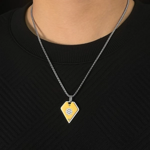 Close-up of vintage rudder necklace pendant on black knit sweater for men