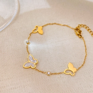 Dettaglio bracciale a farfalla dorato con inserto in madreperla e pietre in zircone