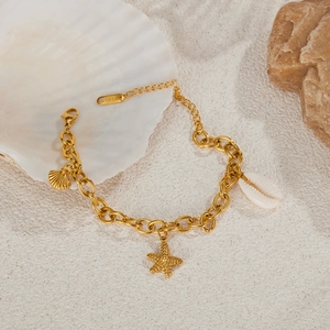 Dettaglio del bracciale dorato in acciaio inossidabile con ciondoli a conchiglia e stella