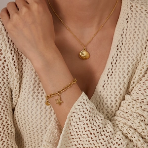 Set di gioielli dorati con collana a conchiglia e bracciale con stella marina per donna