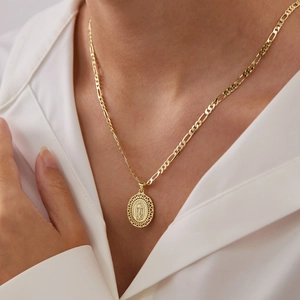 Vintage Maria-hanger in reliëf met gouden Figaro-ketting gedragen door een vrouwelijk model