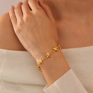 Bracelet étoile de mer en acier titane doré porté au poignet pour un look de plage chic
