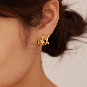 Close-up of interlocking gold triple hoop earrings with cubic zirconia stones on model