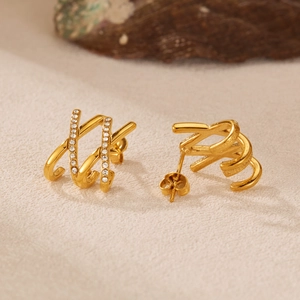 Luxurious gold-plated titanium steel earrings with zircon inlay on a warm fabric background