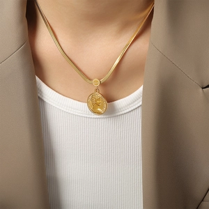 Retro gold snake chain necklace with embossed portrait coin pendant worn by a model