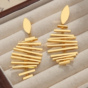 Elegant gold leaf earrings with geometric tiered metal bars on beige fabric