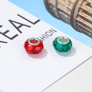 Macro shot of faceted red and green resin beads with silver metal cores for DIY jewelry