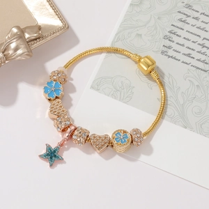 Dettaglio del bracciale con ciondoli in oro rosa con fiori blu e perline di cristallo
