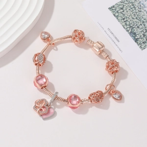 Dettaglio del bracciale a catena serpente oro rosa con charm rosa e ciondolo cuore infinito