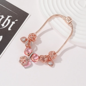 Dettaglio del bracciale con ciondoli fiore oro rosa con cristalli rosa e cuori