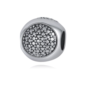Détail macro de perles creuses argentées avec texture granulaire pour la création de bijoux