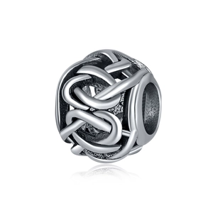 Gros plan détaillé d'une perle charm évidée en argent avec texture polie tissée