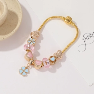 Dettaglio del bracciale in oro rosa con cuori in smalto rosa e perle floreali blu
