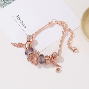 Dettaglio di un bracciale a maglia snake in oro rosa con charm in cristallo e tacchi