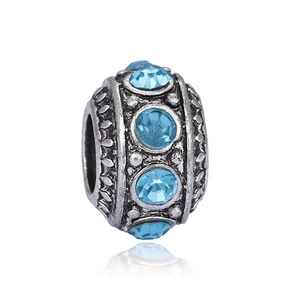 Vue détaillée d'une perle vintage en argent avec motifs gravés et pierre en cristal bleu