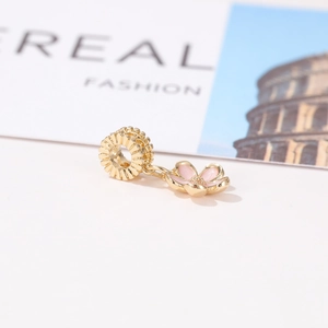 Detailed close-up of a golden cherry blossom enamel flower charm with radial texture ring